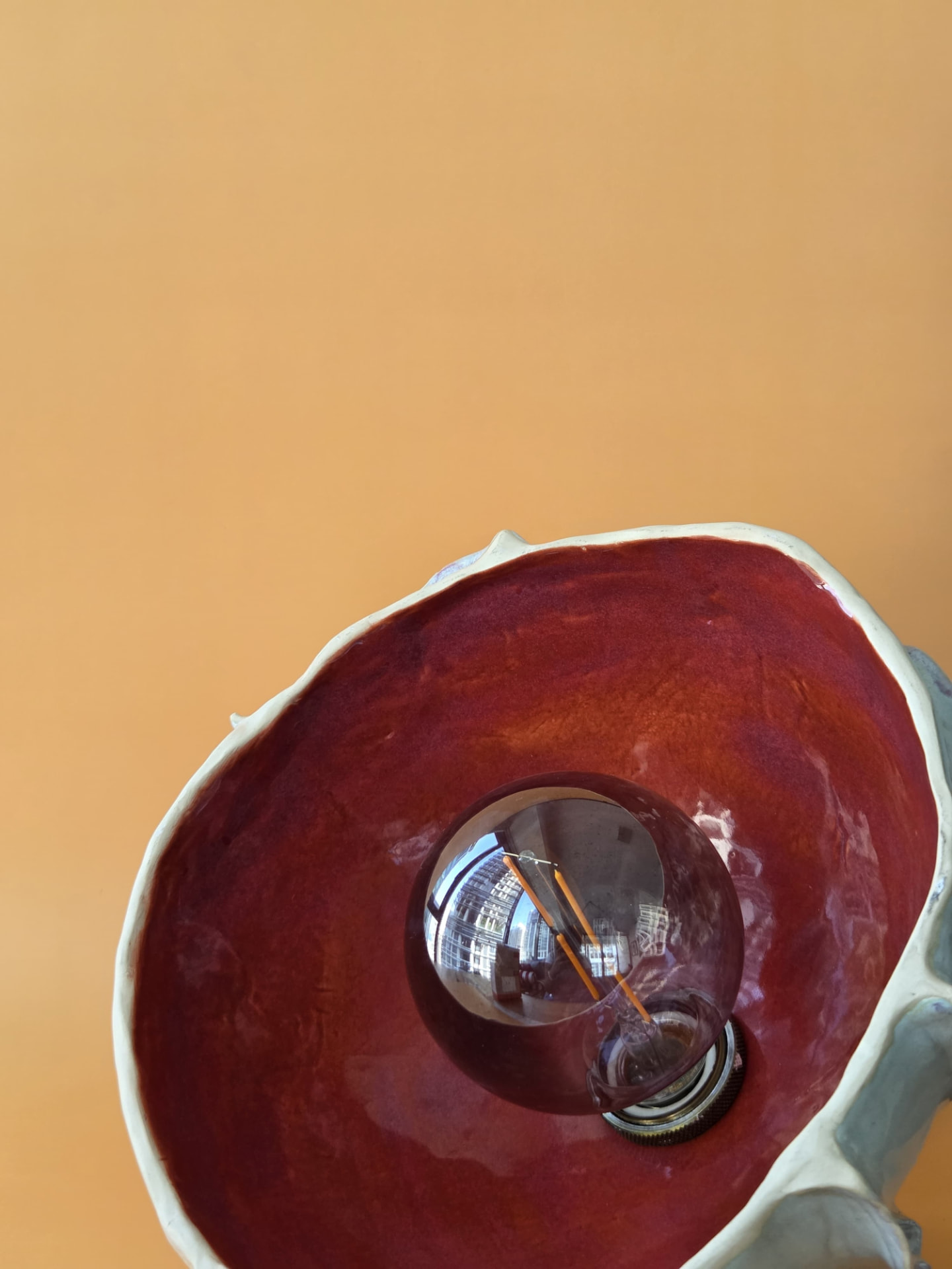 Interior view of Coralline showing the warm-toned glaze and exposed bulb