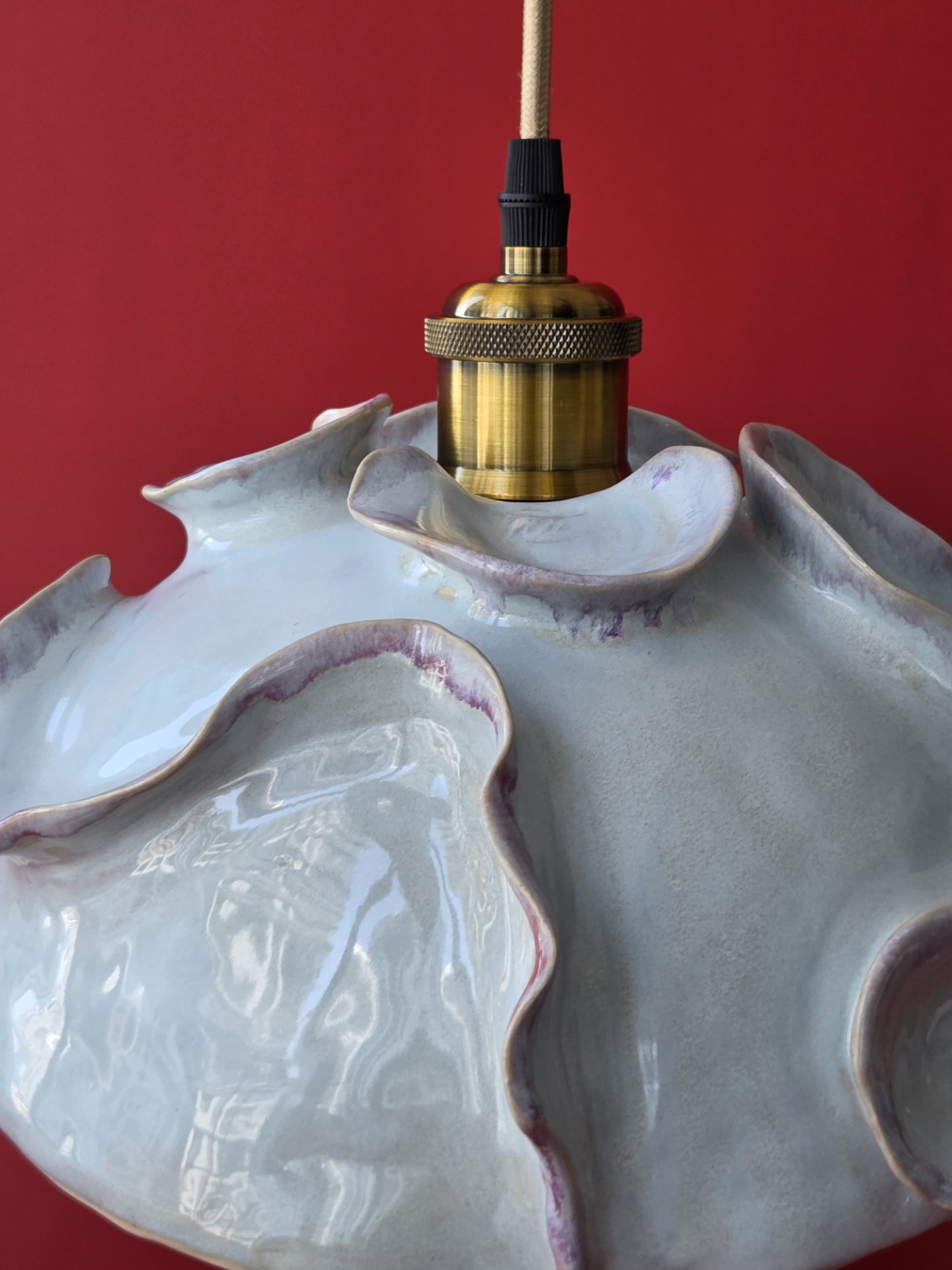 Close detail of Coralline's ruffled rim, pale glaze and brass fixture