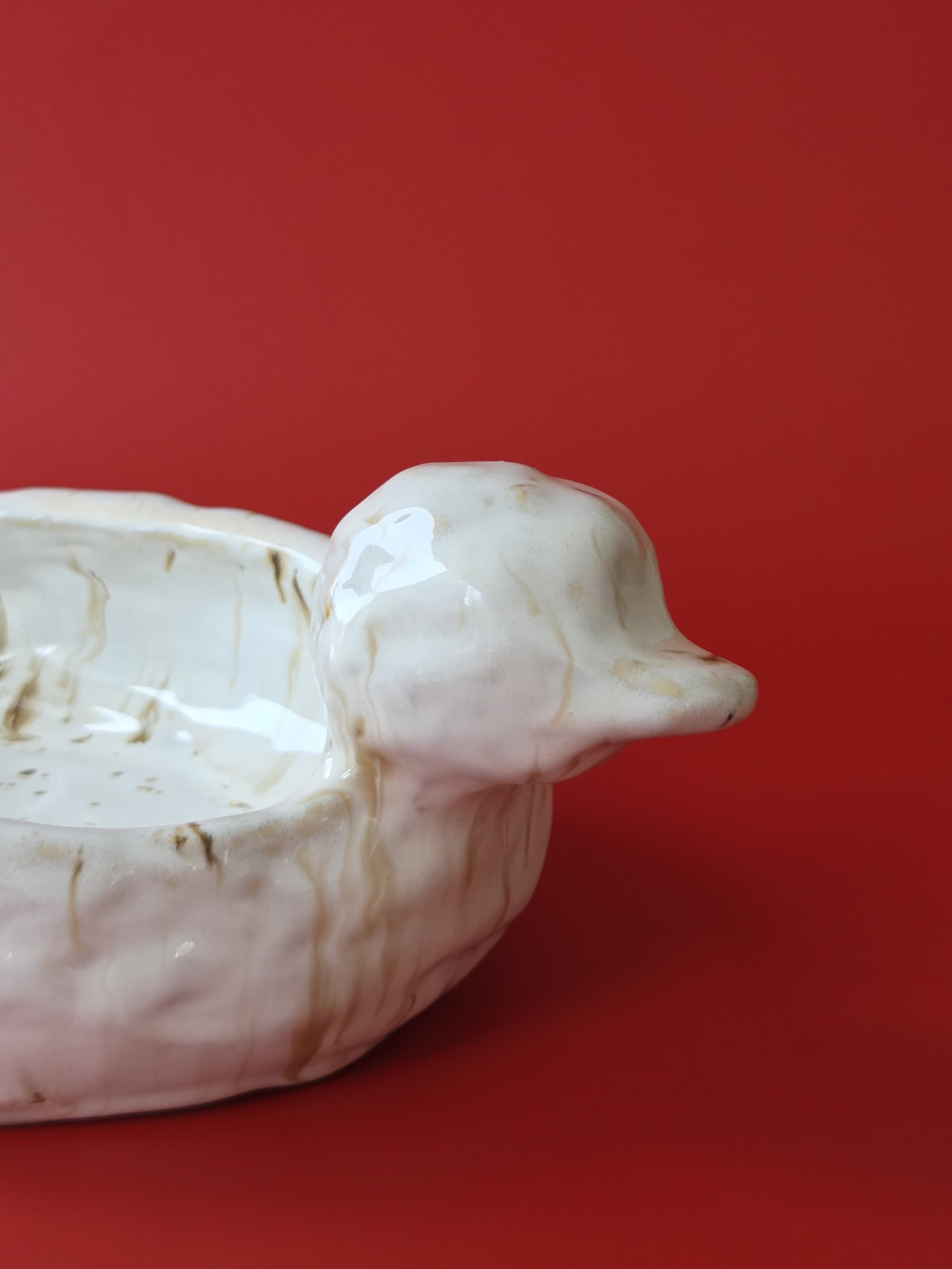 Detail of Mooring's sculpted head and beak with cream and ochre glaze